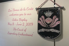 Las Doñas de la Corte logo with a welcome statement reading "Las Doñas de la Corte welcomes you to our Robes Display May 8 through June 2, 2019 The Court of Legendary Enchantment"