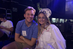 A duchess and an escort next to each other smiling at the camera