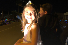 A child of the court on a float  smiling at the camera