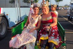 Two duchesses sitting on the rear seats of a club car smiling at the camera