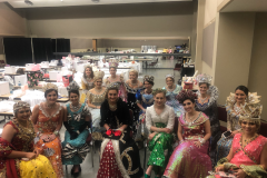 Fifteen duchesses sitting down taking a picture together smiling at the camera